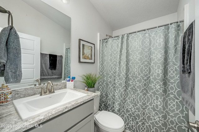 full bathroom featuring a textured ceiling, vanity, and toilet