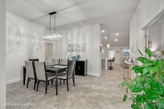 dining area featuring baseboards and an inviting chandelier