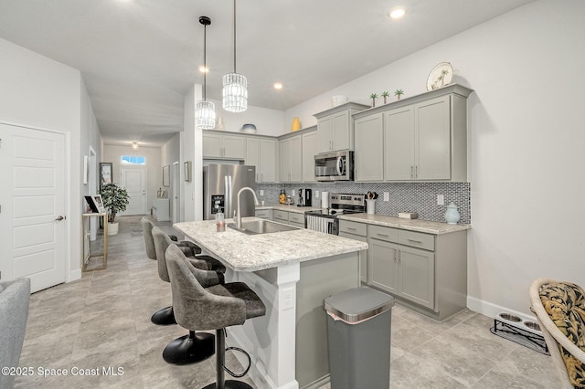 kitchen with backsplash, appliances with stainless steel finishes, gray cabinetry, and a sink