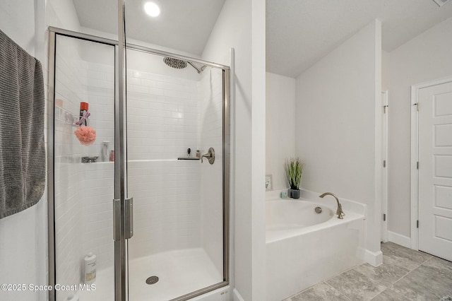 bathroom with baseboards, a bath, and a shower stall