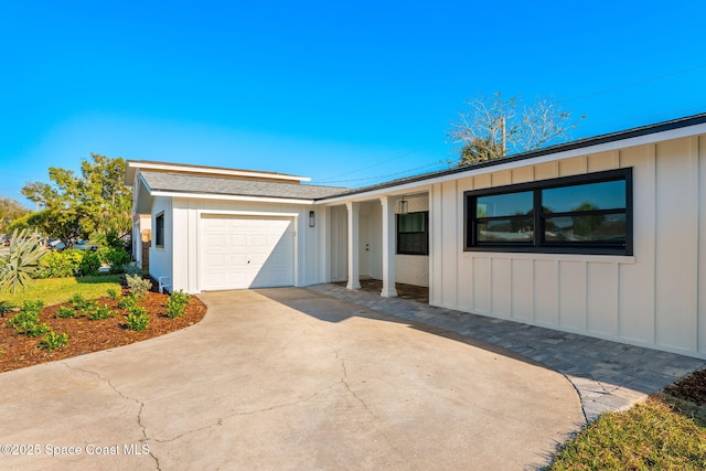 ranch-style house featuring board and batten siding, an attached garage, and driveway