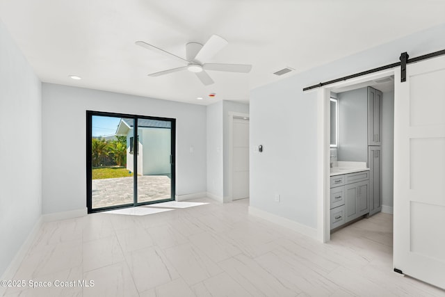 interior space with a barn door, access to outside, baseboards, and visible vents