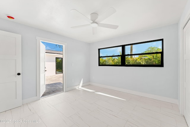 empty room featuring baseboards, marble finish floor, and ceiling fan