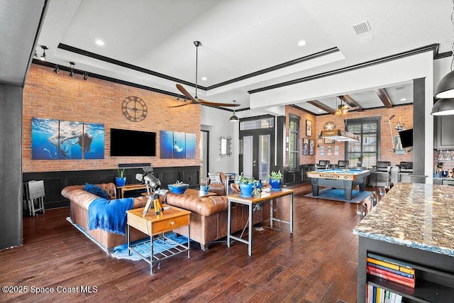 living room with visible vents, brick wall, ceiling fan, and wood finished floors