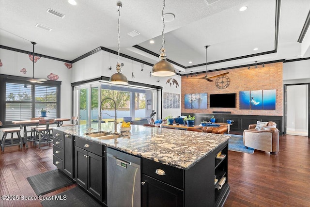 kitchen featuring a sink, dark cabinets, a raised ceiling, and stainless steel dishwasher