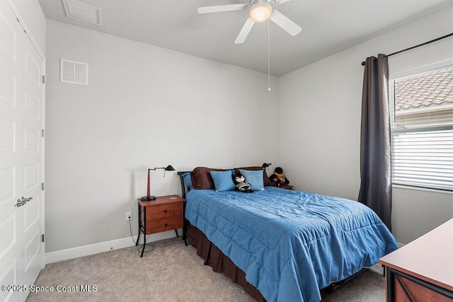 bedroom featuring visible vents, multiple windows, and light carpet