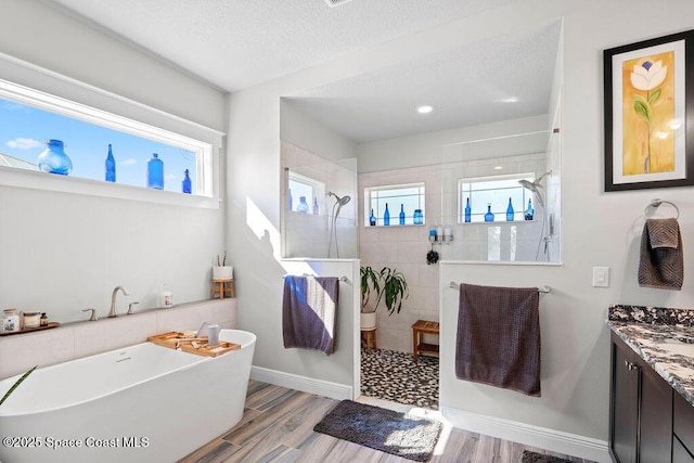 full bathroom with a soaking tub, wood finished floors, a wealth of natural light, and walk in shower