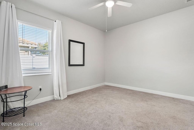 empty room with visible vents, baseboards, carpet, and a ceiling fan