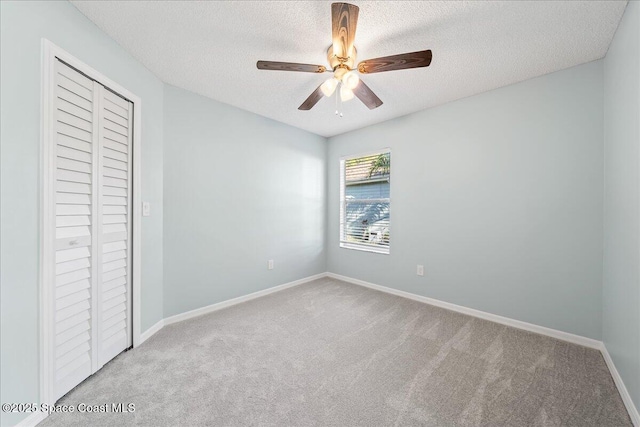 unfurnished bedroom featuring carpet, baseboards, a closet, and a textured ceiling