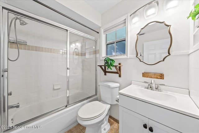 full bathroom with vanity, toilet, combined bath / shower with glass door, and tile patterned flooring