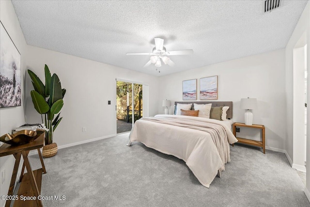 carpeted bedroom with visible vents, baseboards, a textured ceiling, and access to outside