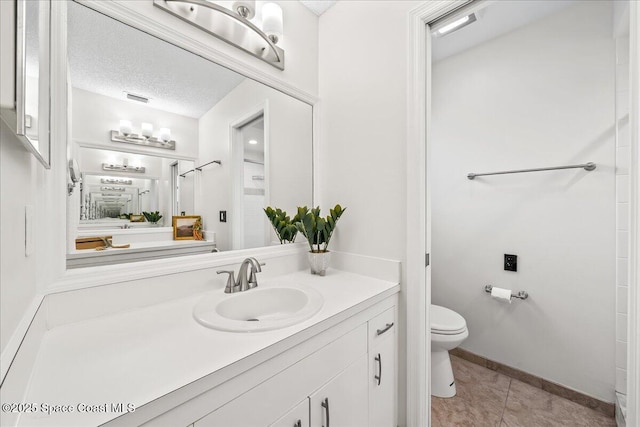 bathroom with tile patterned floors, visible vents, toilet, a textured ceiling, and vanity