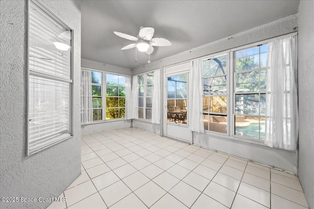 unfurnished sunroom featuring a ceiling fan