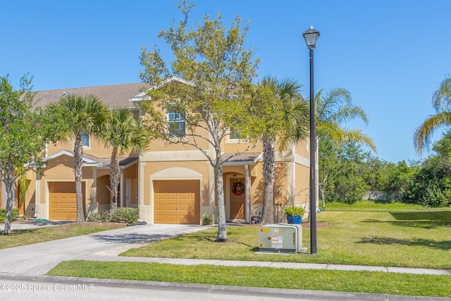2705 Revolution St Unit 106, Melbourne, FL 32935 - view of front of home featuring a front lawn, an attached garage, driveway, and stucco siding