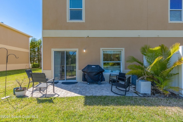 2705 Revolution St Unit 106, Melbourne, FL 32935 - rear view of house featuring stucco siding, a patio, and a yard