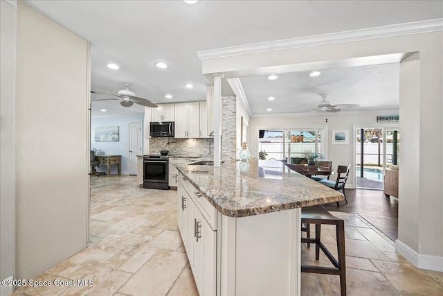 380 Greenway Ave, Satellite Beach, FL 32937 - kitchen with stone tile flooring, stainless steel appliances, and ceiling fan