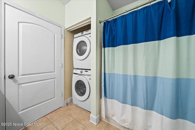 laundry area featuring laundry area, stacked washer and dryer, and tile patterned floors