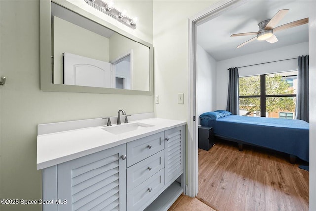 bathroom with a ceiling fan, wood finished floors, and vanity