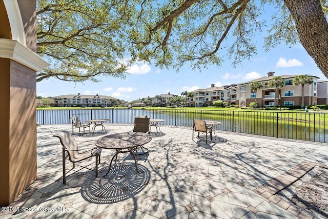 view of patio / terrace with outdoor dining space, a residential view, and a water view