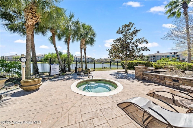 view of swimming pool with a patio, a community hot tub, fence, and a water view