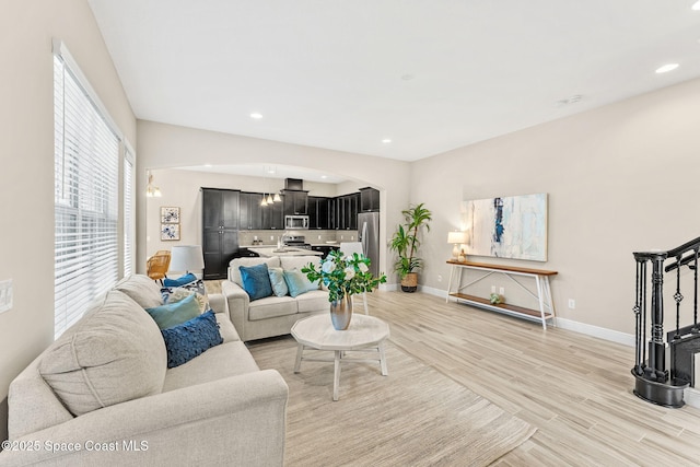 living area featuring recessed lighting, baseboards, and light wood-type flooring