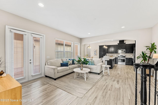 living room featuring recessed lighting, french doors, and light wood-type flooring