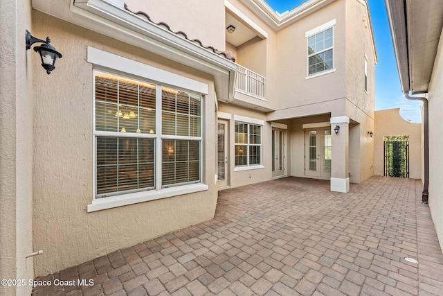 view of patio with french doors and a balcony