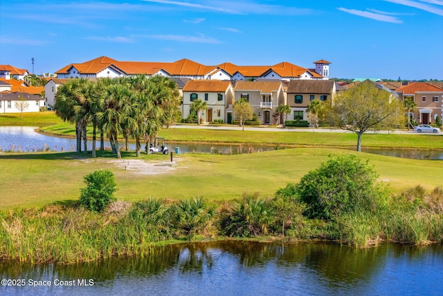 view of property's community with a yard, a residential view, and a water view