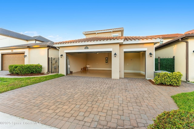 view of front of house featuring stucco siding, an attached garage, and a tiled roof