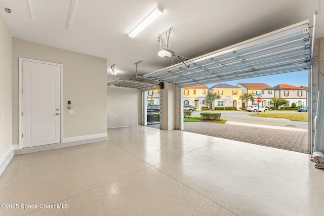 garage featuring a garage door opener and baseboards