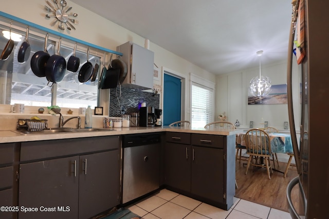 kitchen featuring a peninsula, light countertops, and stainless steel dishwasher