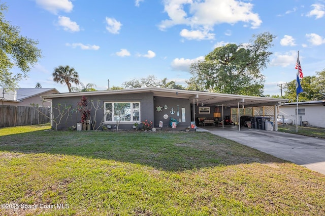 view of front of property with a front lawn, driveway, a carport, fence, and stucco siding