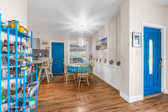 dining area featuring baseboards, a notable chandelier, and wood finished floors