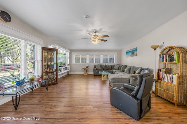 living area featuring baseboards, wood finished floors, and ceiling fan