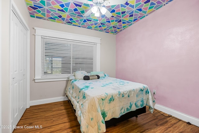 bedroom featuring wood finished floors, a closet, and baseboards
