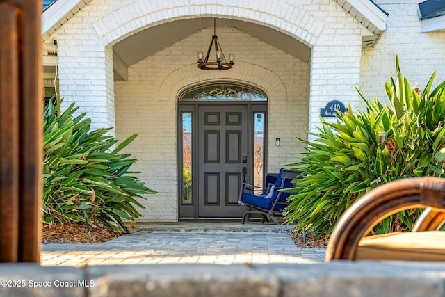 view of exterior entry featuring brick siding