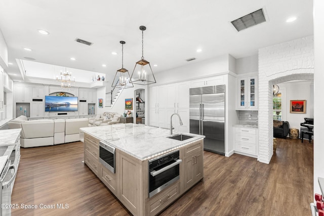 kitchen with visible vents, open floor plan, a notable chandelier, stainless steel appliances, and a sink