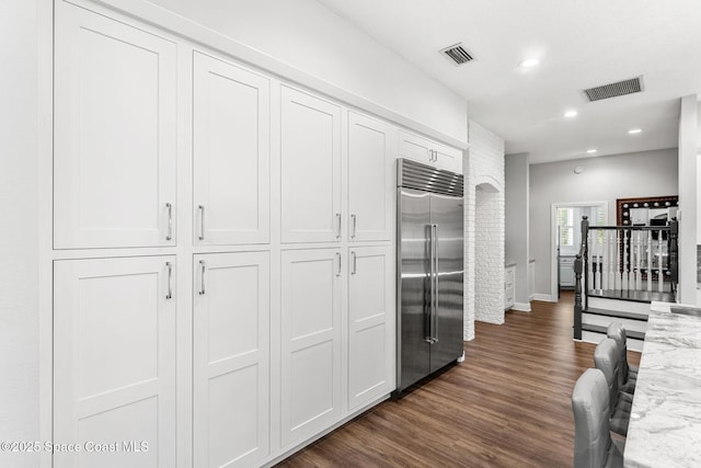 kitchen with stainless steel built in refrigerator, visible vents, recessed lighting, and dark wood-style flooring