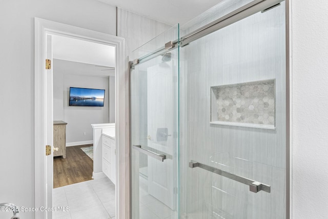 full bath featuring vanity, a shower stall, baseboards, and tile patterned floors