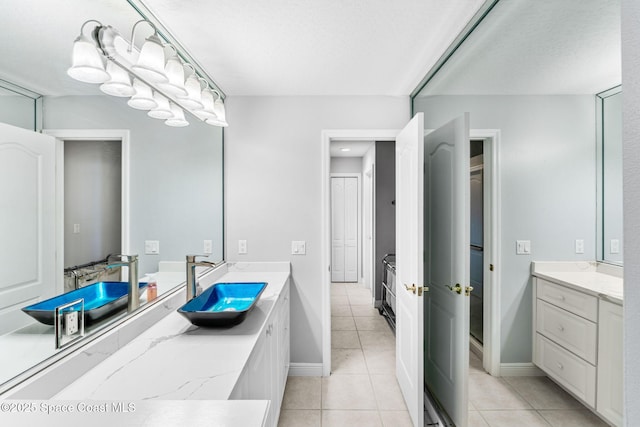 full bath featuring tile patterned flooring, vanity, and baseboards