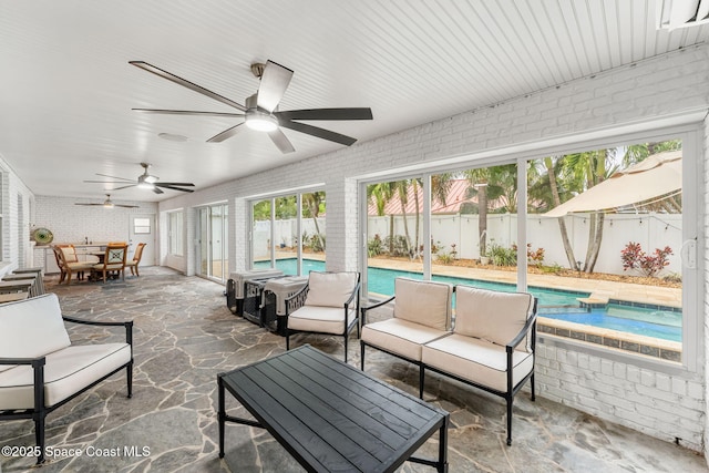 sunroom / solarium featuring a ceiling fan