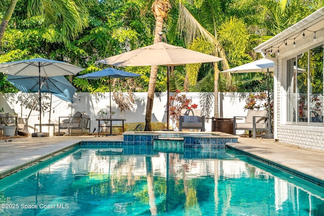 view of swimming pool featuring a patio area, a jacuzzi, fence, and a fenced in pool