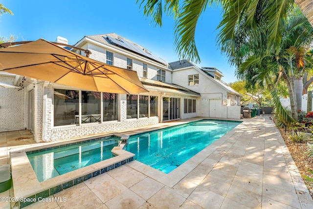 view of pool with a patio area, a pool with connected hot tub, and a fenced backyard