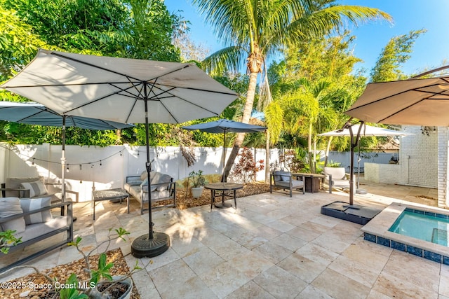 view of patio / terrace with fence and a hot tub