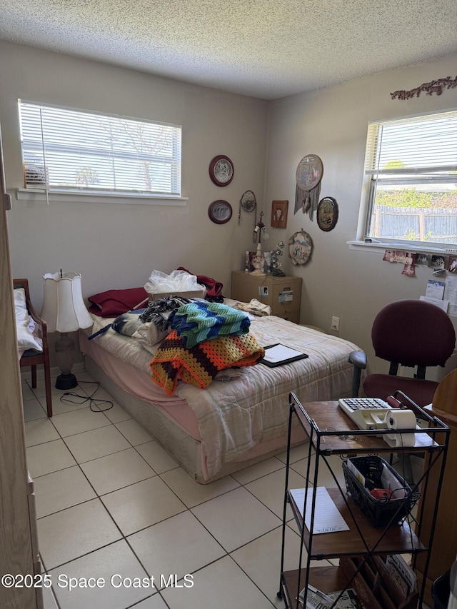 bedroom featuring light tile patterned flooring and a textured ceiling