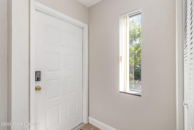 entryway with baseboards and light wood finished floors