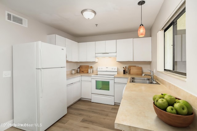 kitchen featuring white appliances, visible vents, a sink, light countertops, and under cabinet range hood