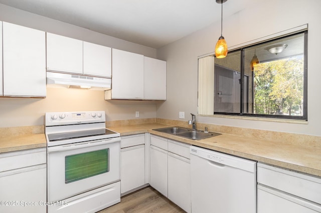 kitchen featuring under cabinet range hood, light countertops, white cabinets, white appliances, and a sink