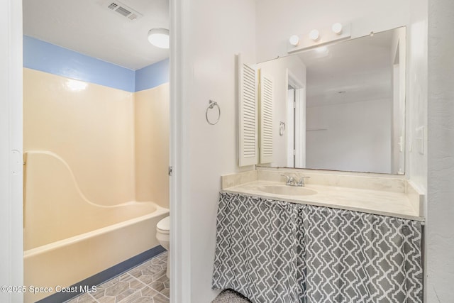 bathroom featuring vanity, toilet, visible vents, and shower / washtub combination