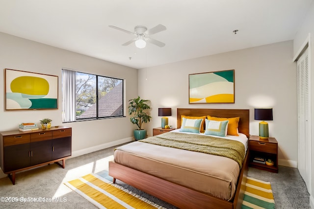 carpeted bedroom with a closet, baseboards, and a ceiling fan